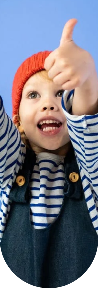 Child smiling and giving a thumbs-up